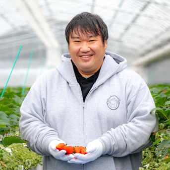 写真：大久保さんがイチゴを両手に持っている様子